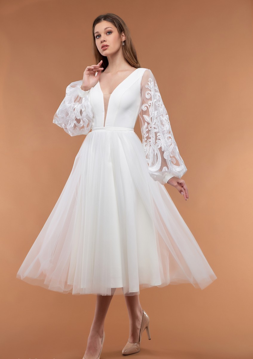 A white dress with an elegant airy sleeve and a lush skirt