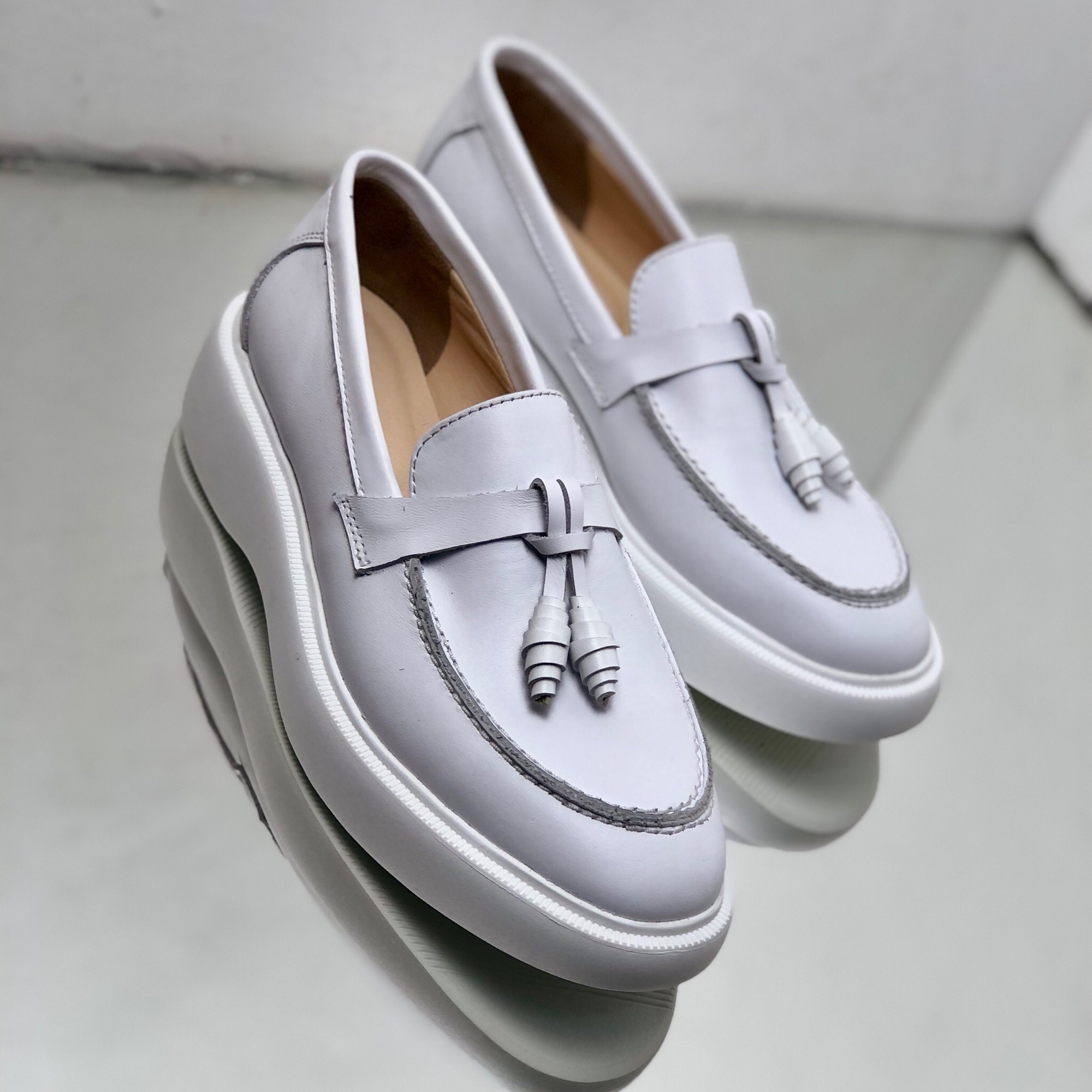 Loafers made of white leather with small decoration