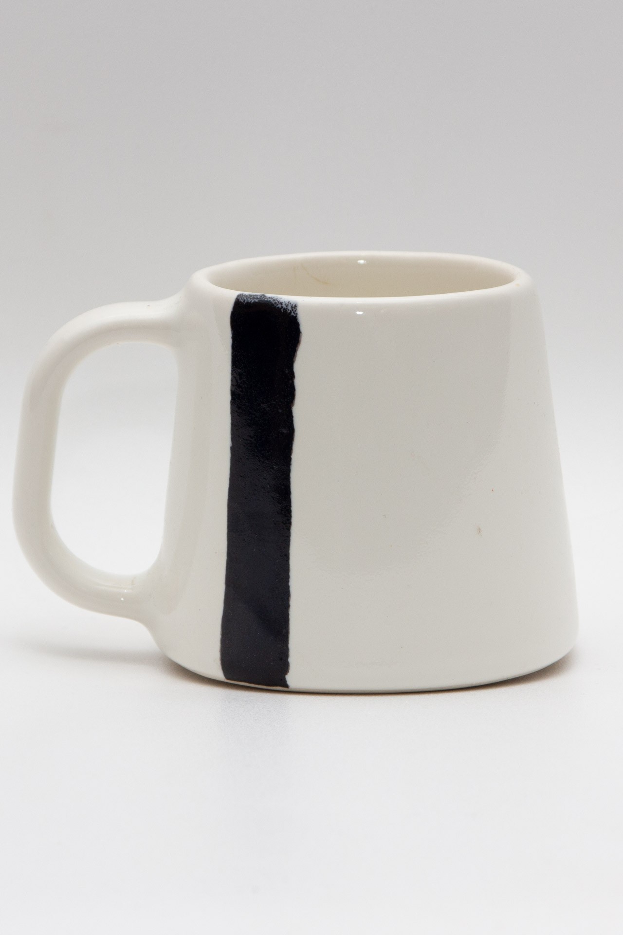 Handmade white ceramic mug with a black stripe