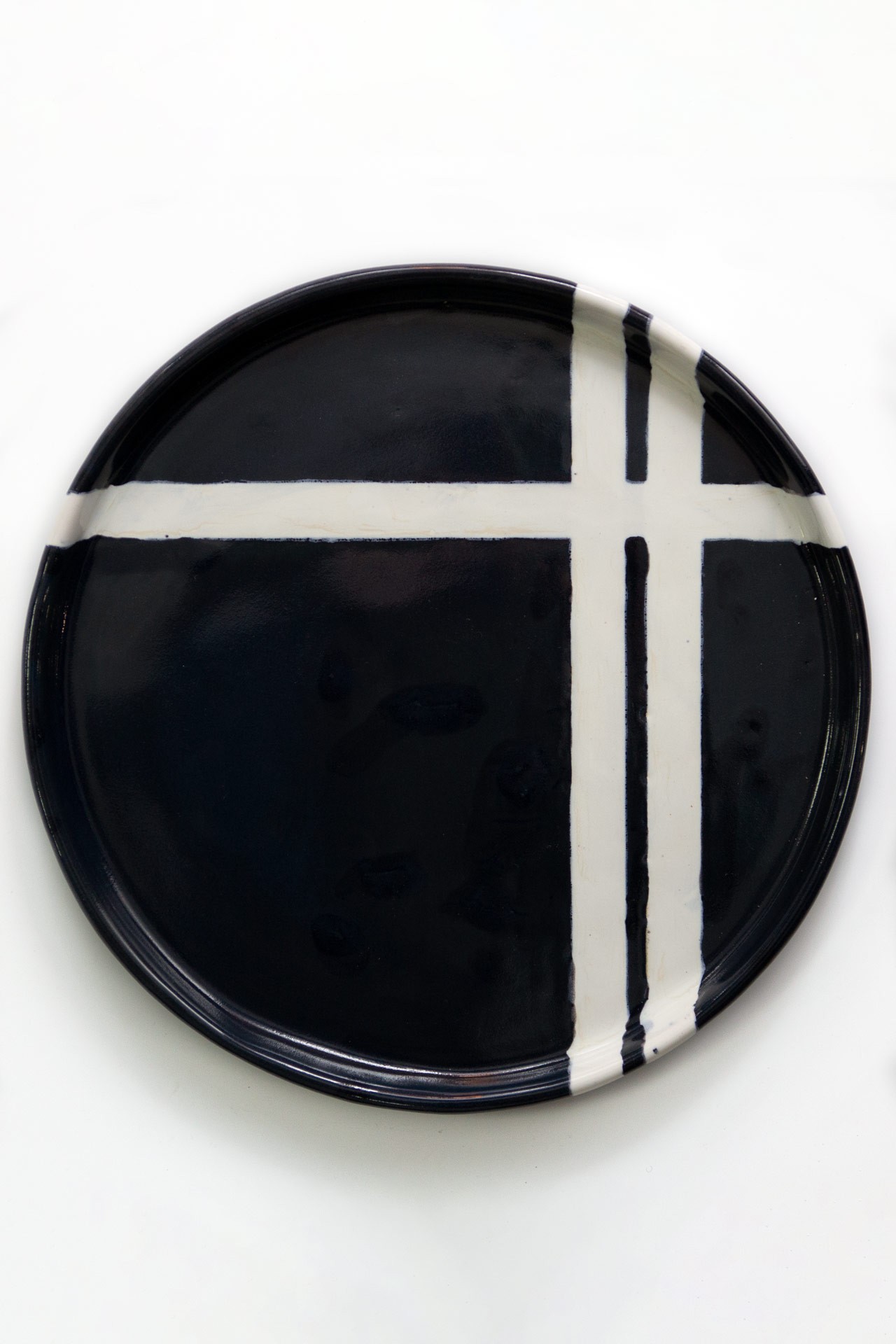 Hand-made dish with flat sides of black color with white stripes