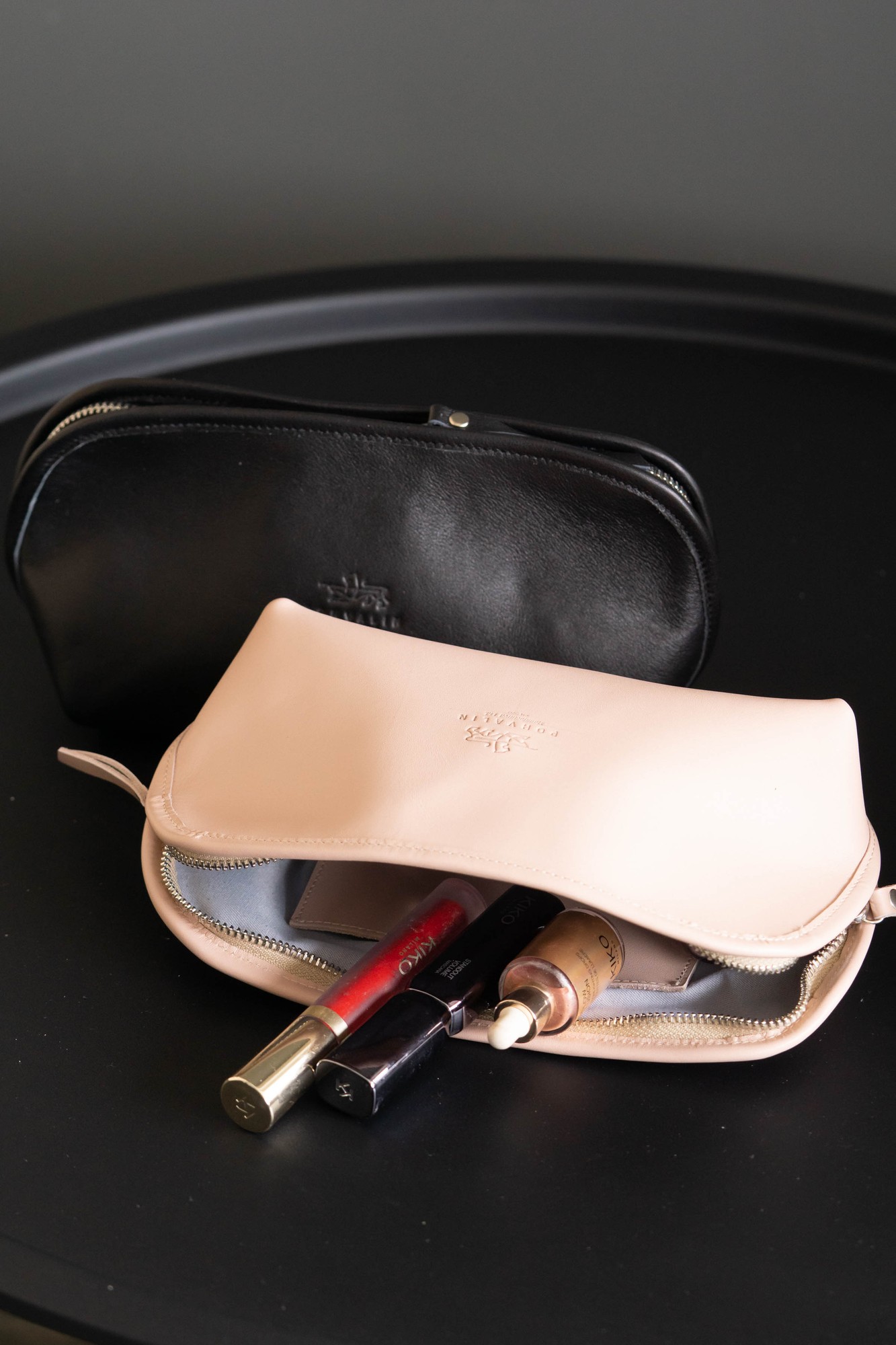 Leather cosmetic bag in black color.